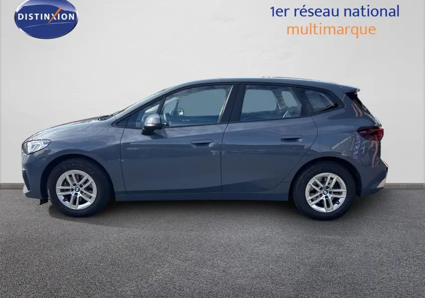 BMW Série 2 Active Tourer 218d gris cuivré vue de profil côté gauche sur fond neutre, jantes alliage visibles.