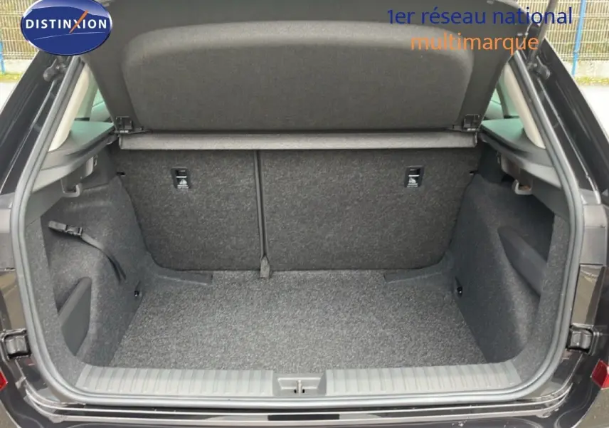 Coffre ouvert vu de l'arrière d'un Skoda Kamiq noir magique métal, montrant l'espace de chargement et la moquette grise.