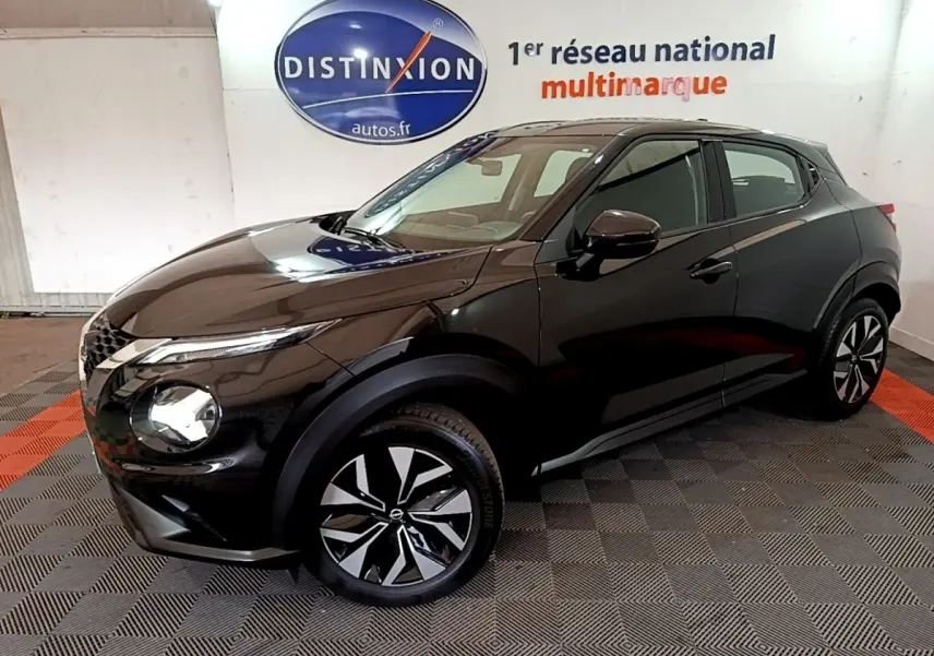 Nissan Juke noir en vue 3/4 avant droit, avec jantes alliage bicolores et phares LED ellipsoïdaux visibles.