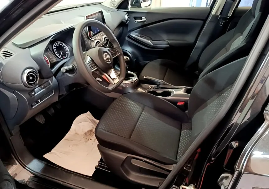 Intérieur noir du Nissan Juke 2023 vu côté conducteur, avec volant multifonctions et tableau de bord digital.