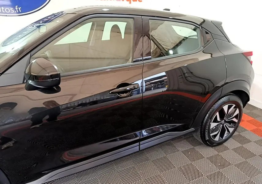 Vue latérale côté droit d'un Nissan Juke noir 2023 avec jantes alliage et rétroviseur ton caisse.
