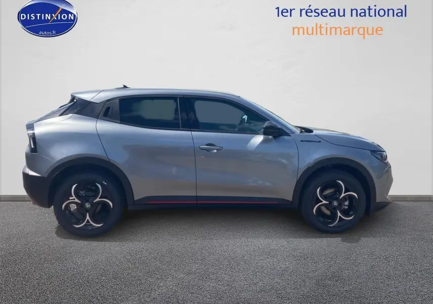 Vue de profil côté gauche d'une Alfa Romeo Junior 1.2 hybride gris métallisé avec jantes alliage noires et rouges discrètes.