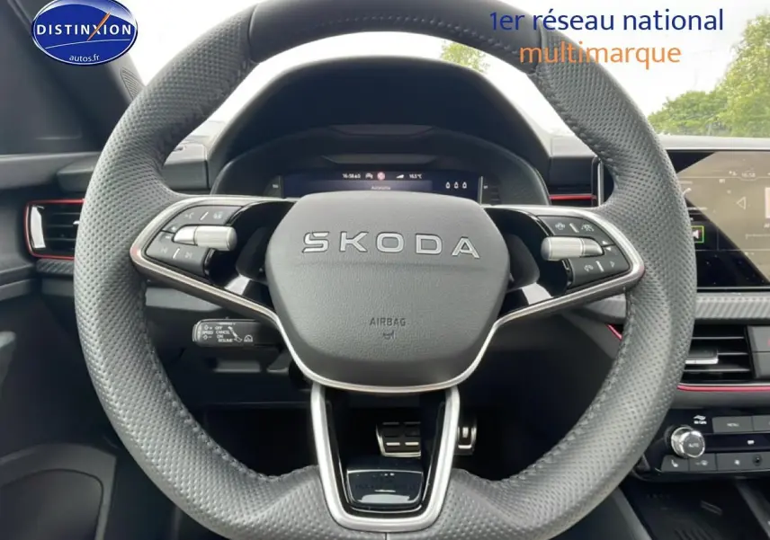 Vue centrée sur le volant cuir perforé noir d'une Skoda Kamiq 2026 avec tableau de bord numérique et écran tactile.