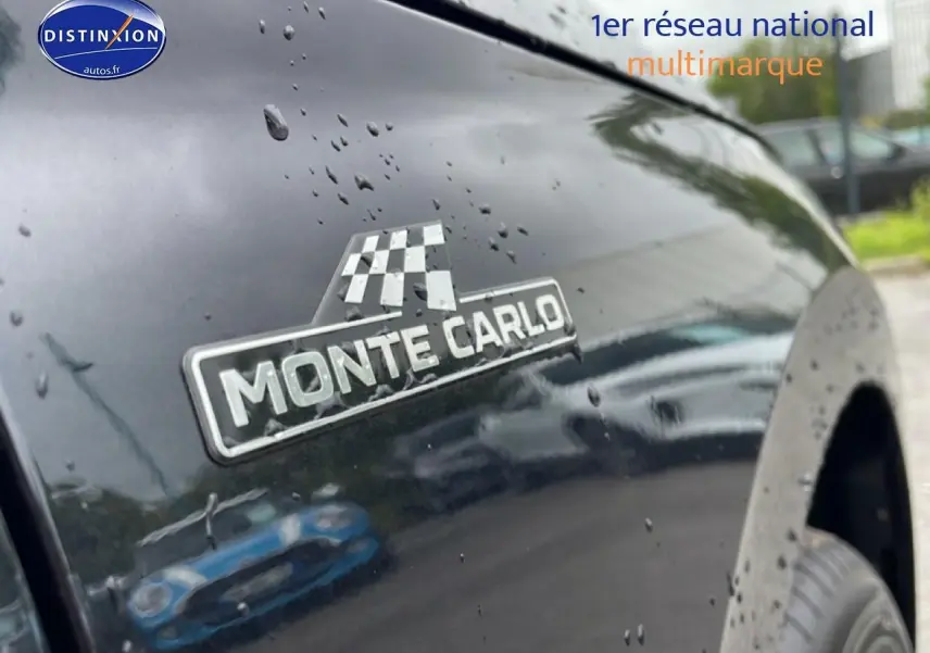 Gros plan sur l'aile avant droite noire d'un Skoda Kamiq Monte Carlo avec logo distinctif sous pluie fine.