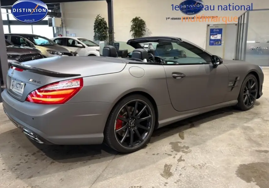 Mercedes Classe SL 63 AMG gris mat vue 3/4 arrière droit, capote ouverte et jantes noires sport.