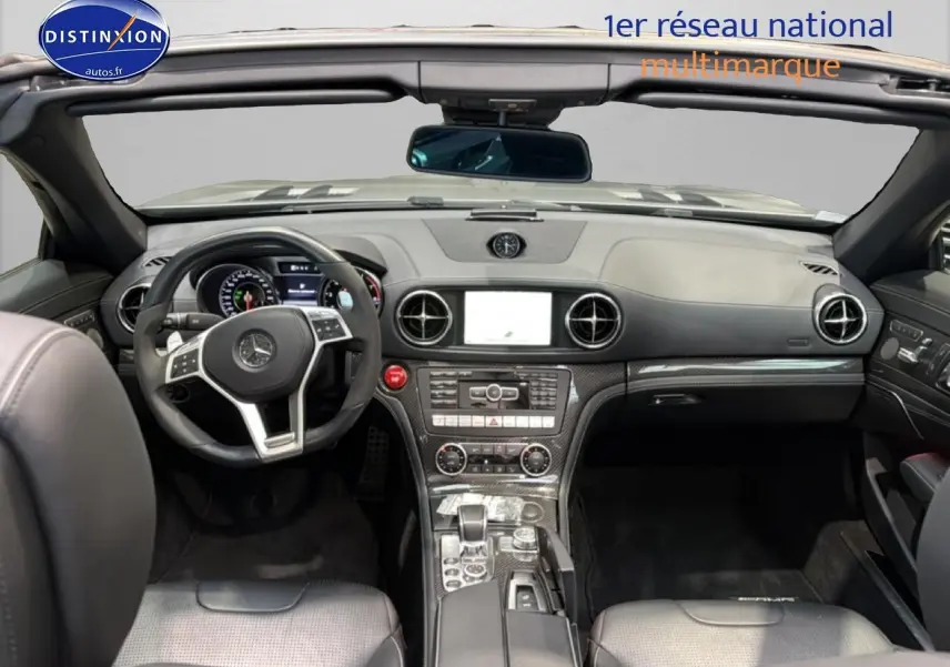 Vue intérieure avant d'une Mercedes Classe SL 63 AMG Speedshift MCT 2013 avec tableau de bord noir et inserts carbone.