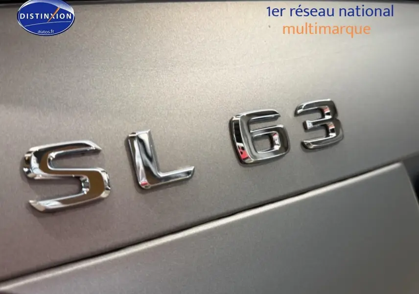 Gros plan sur l’inscription chromée SL 63 sur la carrosserie grise métallisée d’une Mercedes Classe SL.