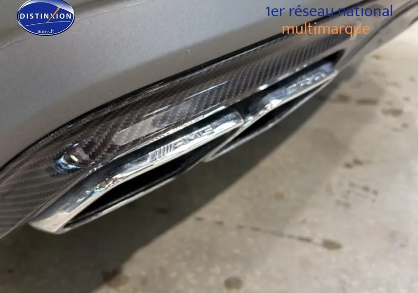 Gros plan sur la sortie d’échappement chromée AMG intégrée dans le diffuseur arrière gris de la Mercedes Classe SL 63 AMG.