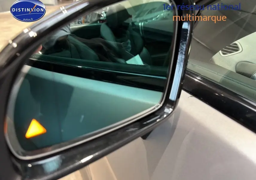 Rétroviseur extérieur droit noir de Mercedes Classe SL 63 AMG avec témoin d'angle mort orange allumé.