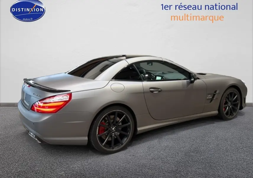 Mercedes Classe SL 63 AMG gris vue 3/4 arrière droit, avec jantes noires et becquet arrière distinctif.