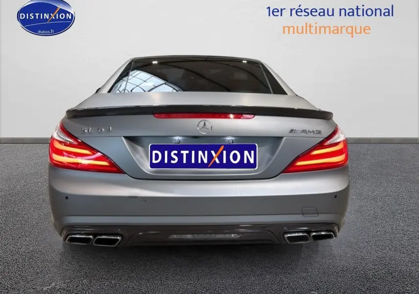 Vue arrière d'une Mercedes Classe SL 63 AMG gris métallisé avec becquet et quadruple sortie d'échappement.