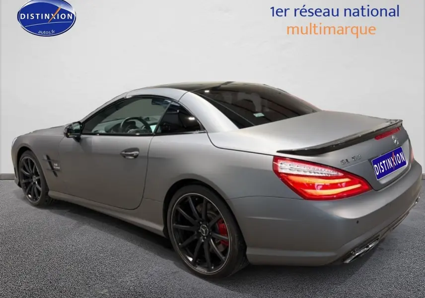 Vue 3/4 arrière droite d'une Mercedes Classe SL 63 AMG gris mat avec jantes noires et becquet arrière.