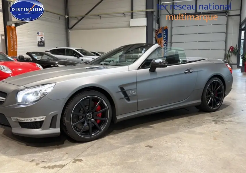 Mercedes Classe SL 63 AMG gris mat vue de profil droit, capote ouverte et jantes noires avec étriers rouges.