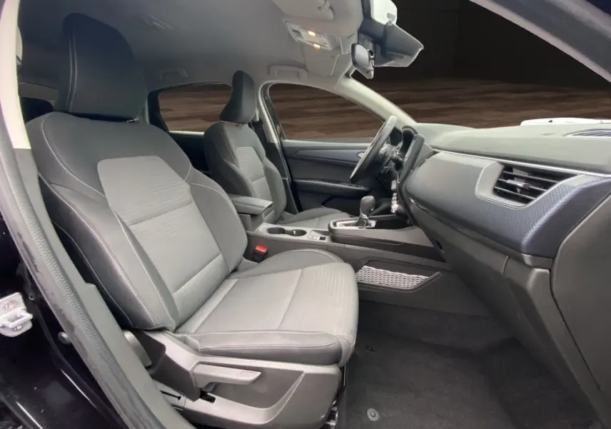 Vue intérieure côté conducteur de la Renault Arkana noire 2024, sièges tissu gris et tableau de bord moderne.
