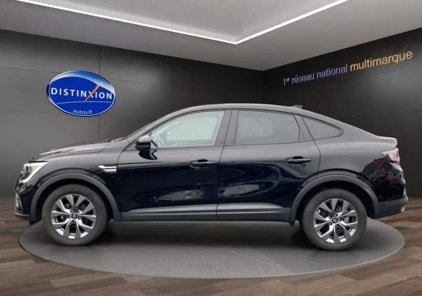 Profil droit d'un Renault Arkana noir 2024 en version Evolution mild hybrid, dans un showroom avec sol en bois.
