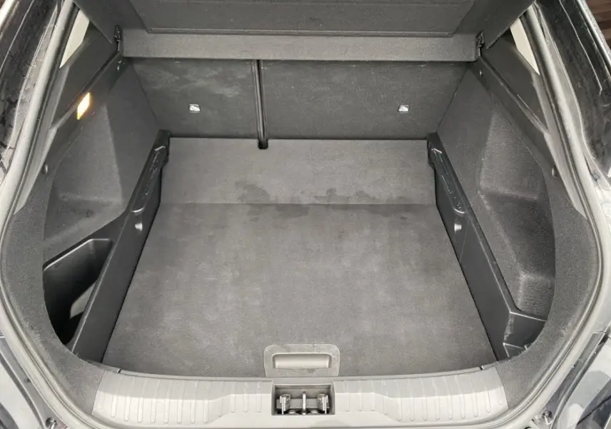 Coffre ouvert vu de dessus du Renault Arkana noir, montrant un espace de chargement propre et bien fini.