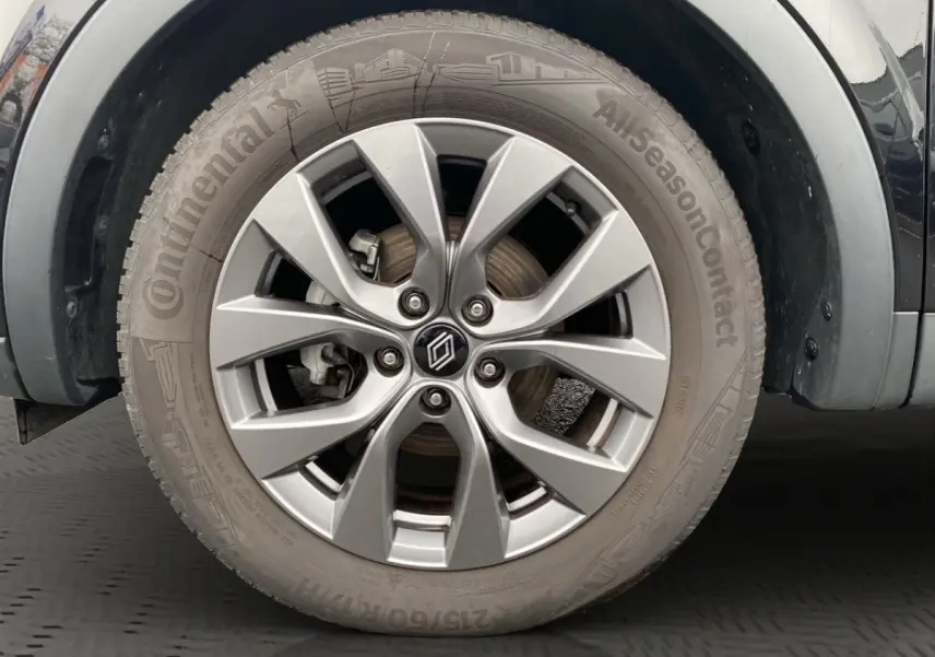 Gros plan sur la roue avant gauche noire du Renault Arkana Evolution avec jante alliage argentée et pneu Continental.
