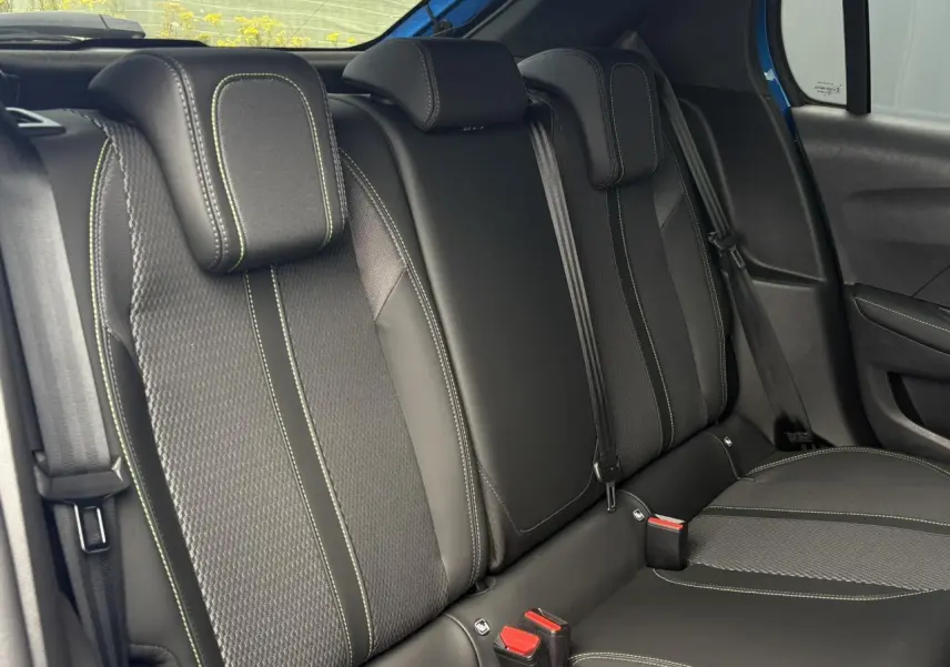 Vue latérale droite de la banquette arrière noire avec surpiqûres vertes de la Peugeot 208 Hybrid 110 e-DSC6 GT.