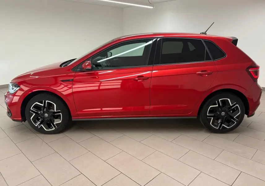 Vue de profil côté gauche d'une Volkswagen Polo 2025 Rouge Roi métallisée avec jantes R-Line distinctives.