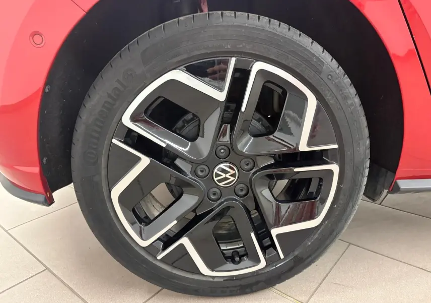Gros plan sur la roue avant droite d’une Volkswagen Polo Rouge Roi, jante alliage noir et argent au design moderne.
