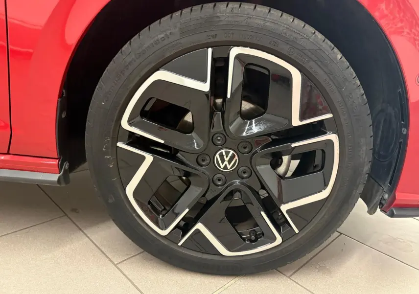 Gros plan sur la jante noire et argentée du côté avant droit d'une Volkswagen Polo Rouge Roi 2025 finition R-Line.