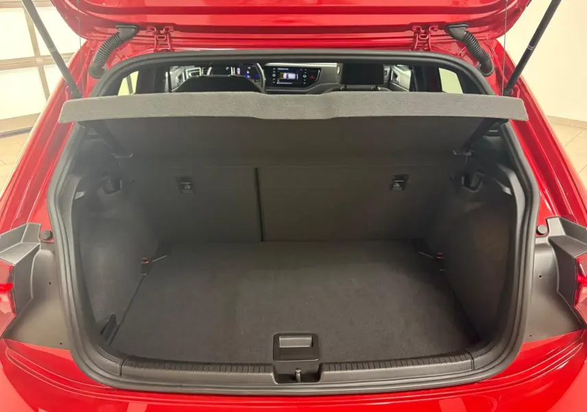 Coffre ouvert d'une Volkswagen Polo Rouge Roi 2025, vue arrière montrant l'espace de chargement et l'intérieur du véhicule.