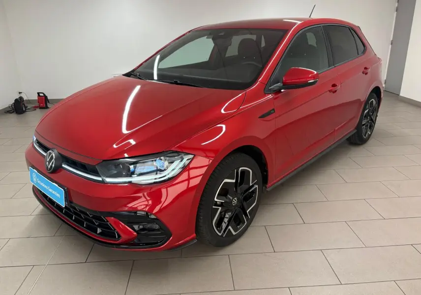 Volkswagen Polo 1.0 TSI R-Line rouge métallisé vue 3/4 avant droit en intérieur avec jantes noires distinctives.