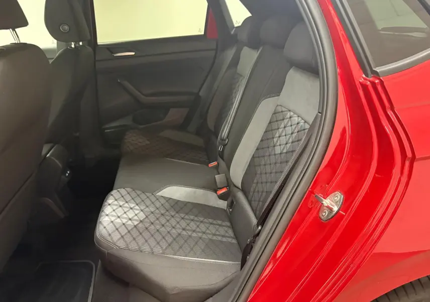Vue intérieure côté arrière droit de la Volkswagen Polo Rouge Roi, montrant les sièges arrière en tissu à motifs géométriques.