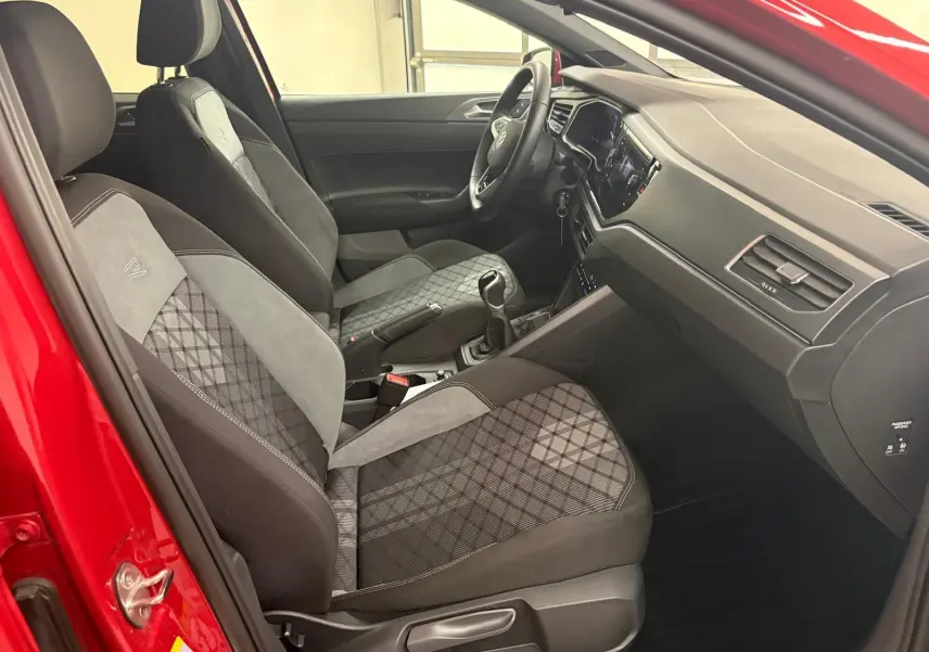 Vue intérieure côté conducteur de la Volkswagen Polo Rouge Roi 2025 avec sièges R-Line en tissu et alcantara.