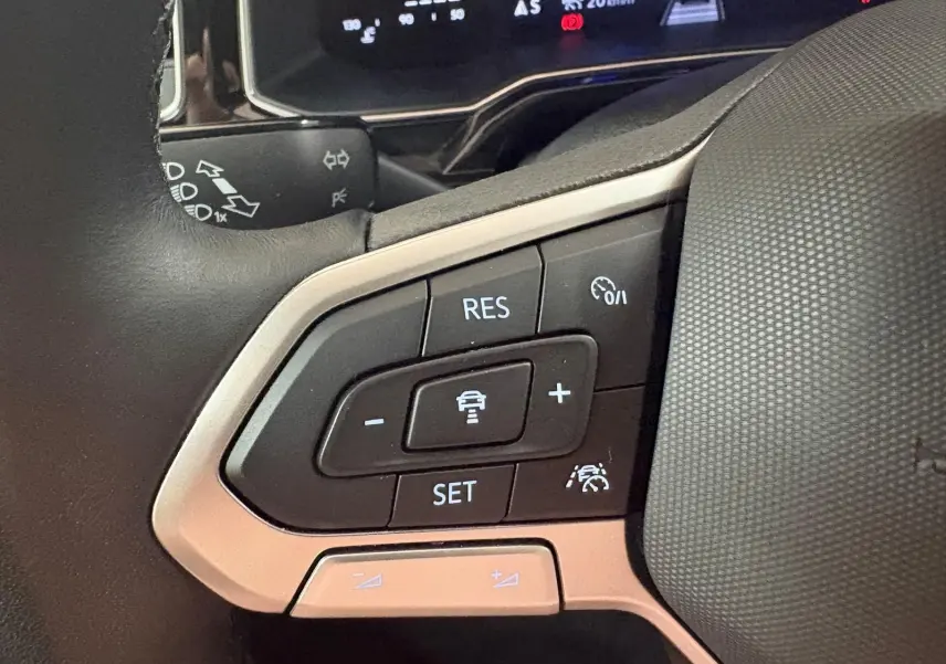 Gros plan sur les commandes de régulateur de vitesse au volant d’une Volkswagen Polo Rouge Roi 2025.