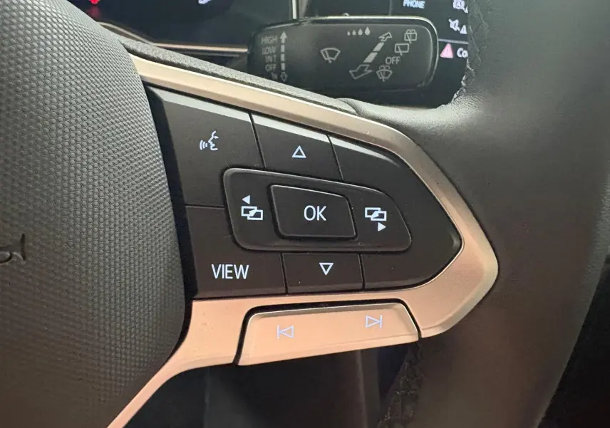 Gros plan sur les commandes multifonctions au volant d'une Volkswagen Polo 2025, finition R-Line.