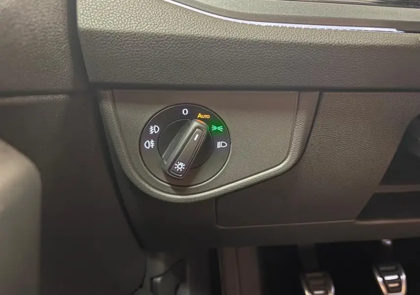 Gros plan sur le sélecteur d'éclairage intérieur noir du Volkswagen Polo Rouge Roi, côté gauche du tableau de bord.