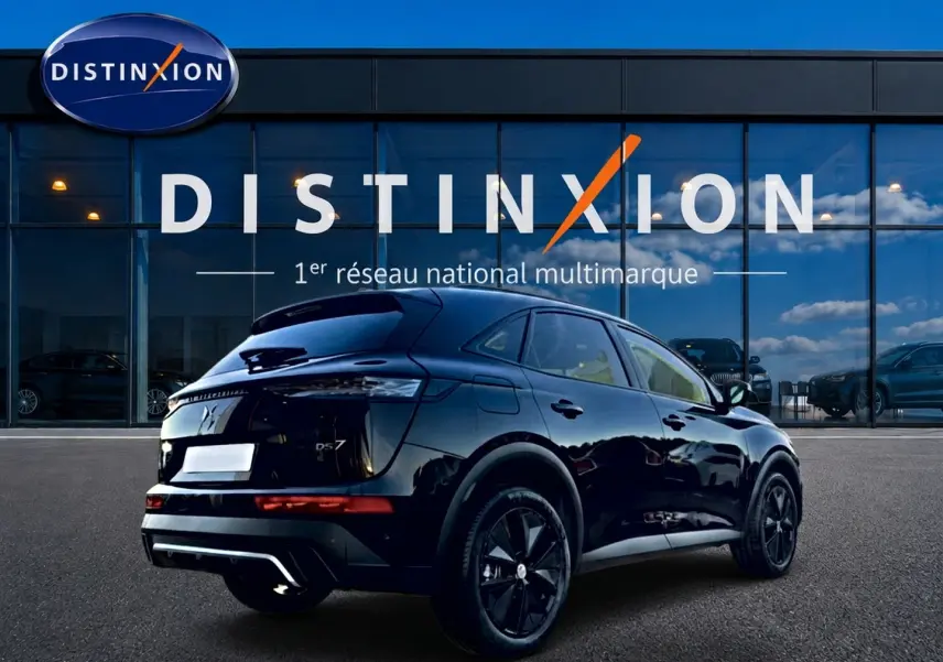 Vue 3/4 arrière droite du SUV DS7 noir brillant avec jantes noires, devant une vitrine Distinxion.