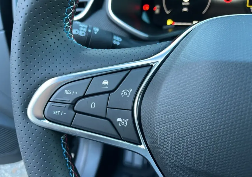 Gros plan sur le côté gauche du volant cuir perforé de la Renault Clio V E-Tech 145 Esprit Alpine Bose 2025.