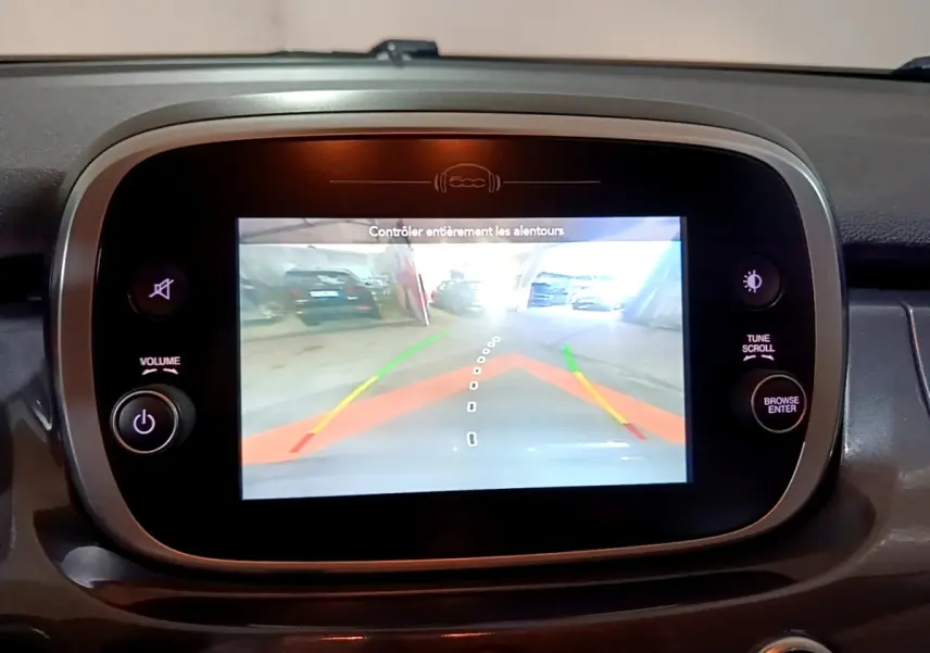 Écran tactile central de la Fiat 500X gris foncé montrant la caméra de recul avec guidage dynamique.