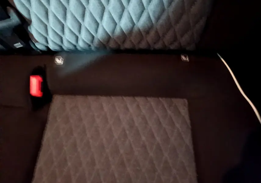 Vue rapprochée de la banquette arrière gris foncé matelassée du Fiat 500X 2019 avec ceinture rouge visible.