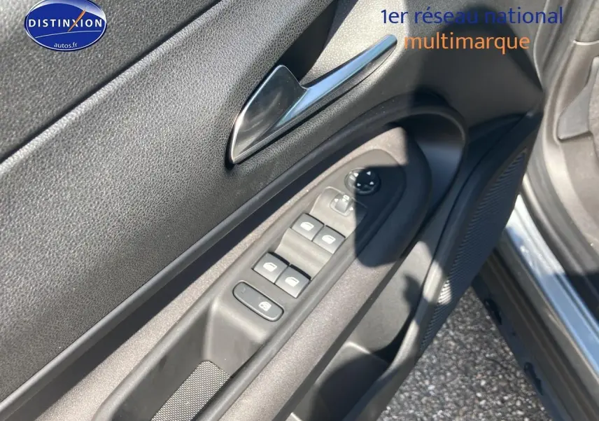 Vue rapprochée de la porte conducteur d'une Alfa Romeo Junior 1.2 hybride gris t/noir, montrant les commandes des vitres et rétroviseurs.
