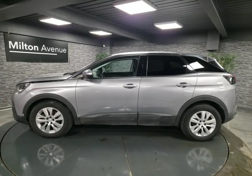 Profil droit d'un Peugeot 3008 gris métallisé 2018 en intérieur avec jantes alliage 17 pouces.