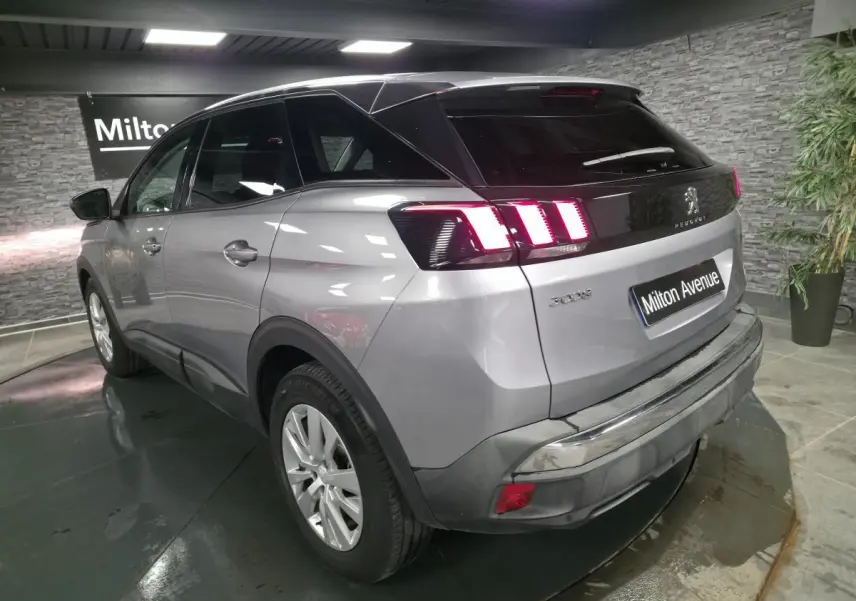 Vue 3/4 arrière droite d’un Peugeot 3008 gris métallisé avec feux arrière LED et jantes alliage 17 pouces.