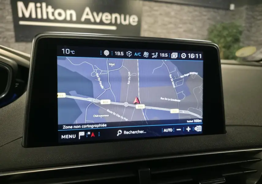 Écran tactile central du Peugeot 3008 gris, affichant la navigation GPS avec carte et informations climatiques.