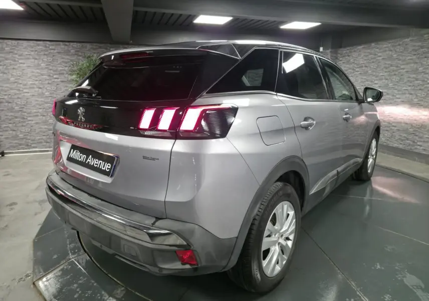 Vue 3/4 arrière droite d’un Peugeot 3008 gris métallisé avec feux arrière à LED et toit noir contrasté.