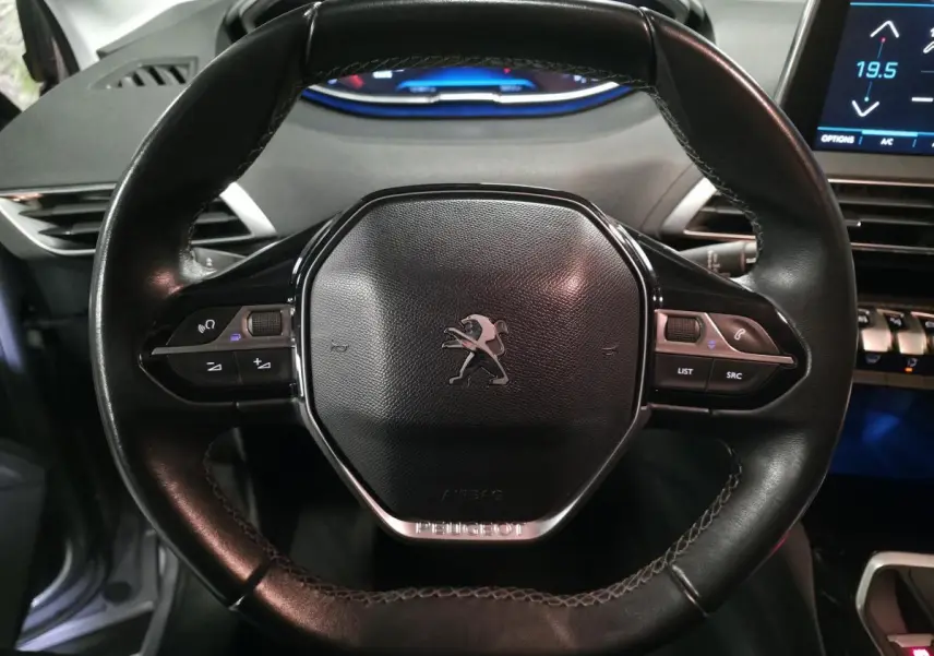 Volant cuir noir compact de Peugeot 3008 2018 avec commandes multifonctions et logo lion central.