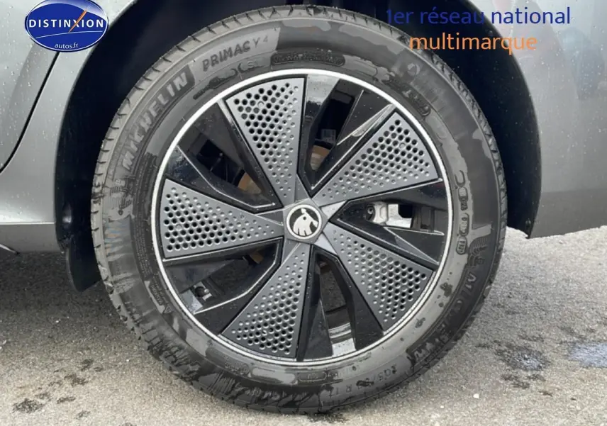 Gros plan sur la roue avant gauche gris graphite d’un Skoda Kamiq avec jante alu noire et grise à motifs perforés.