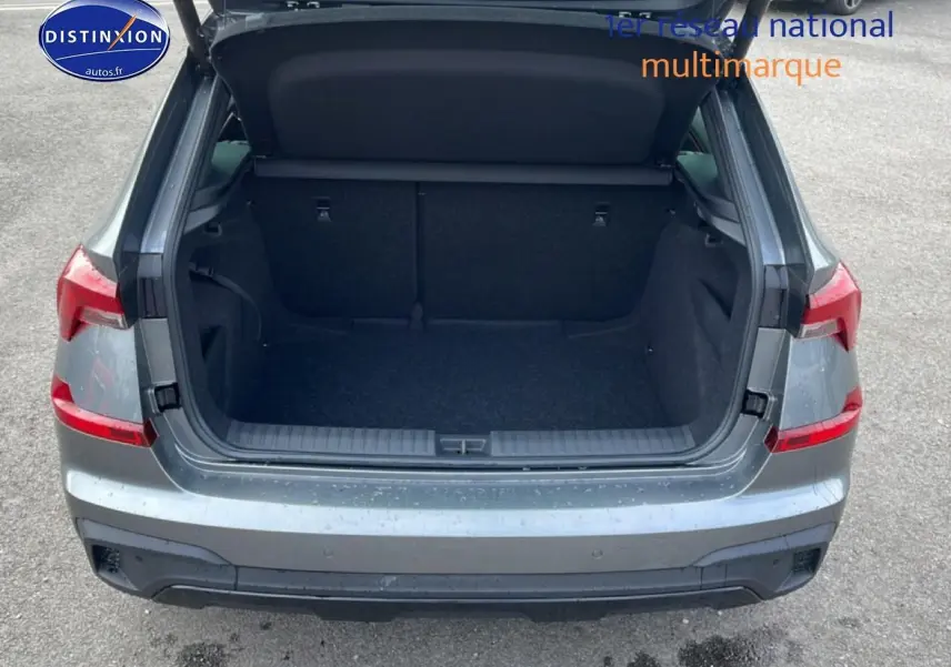 Vue arrière du coffre ouvert d'un Skoda Kamiq gris graphite, montrant l'espace de chargement vide et les feux arrière LED.
