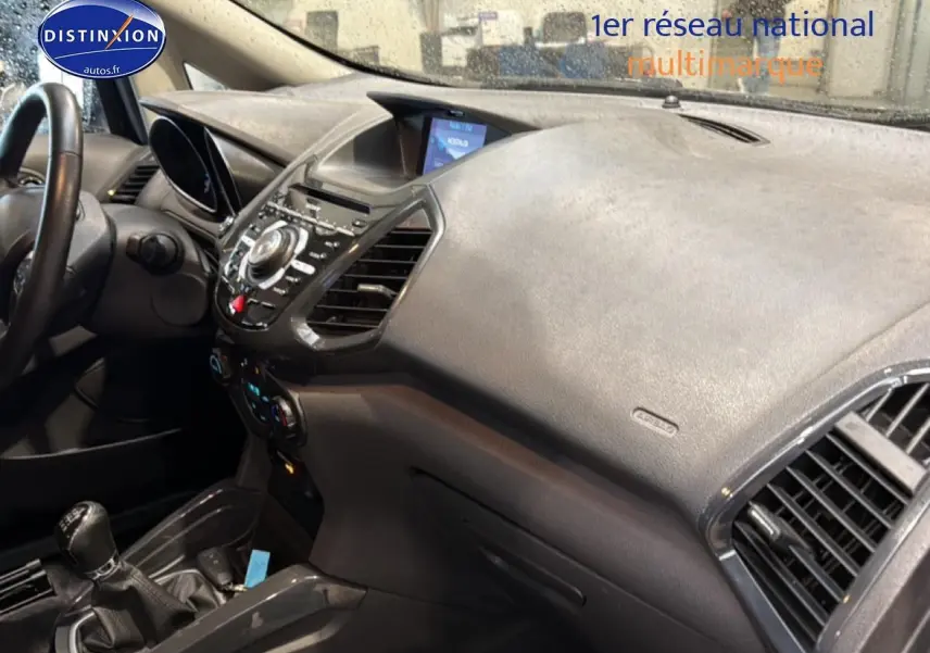 Vue intérieure côté passager du tableau de bord noir du Ford Ecosport 2017 avec console centrale et levier de vitesse manuel.