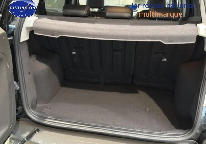 Coffre ouvert d’un Ford EcoSport noir 2017, vue de l’arrière montrant la tablette cache-bagages et la banquette rabattable.