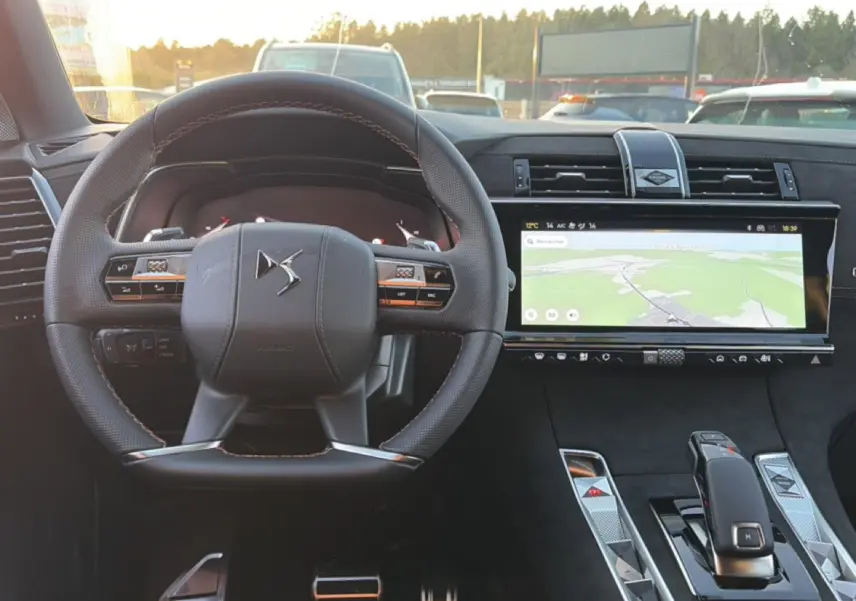 Vue intérieure centrée sur le volant cuir noir et l'écran tactile large affichant la navigation du DS7 2026.