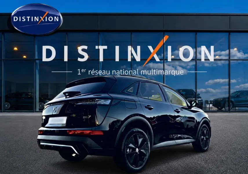 Vue 3/4 arrière droite d'un DS7 noir brillant avec jantes noires devant une vitrine Distinxion.