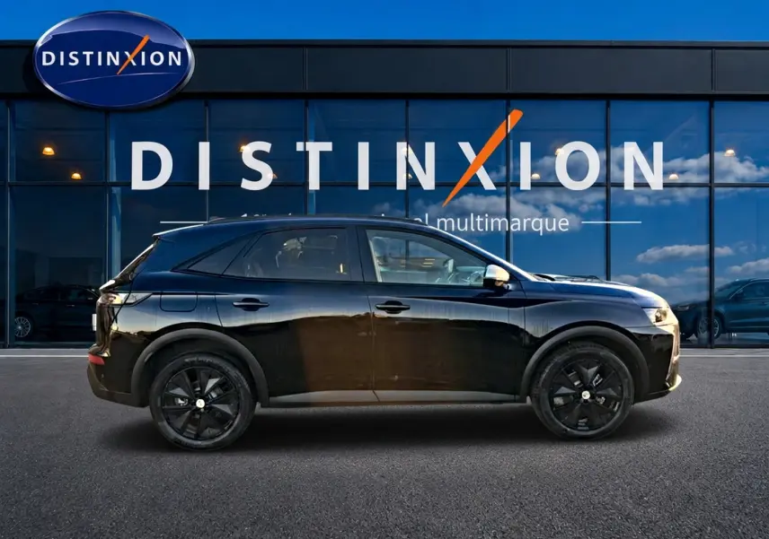 Vue de profil côté gauche d'un DS7 noir 2026 avec jantes noires, garé devant une vitrine Distinxion.