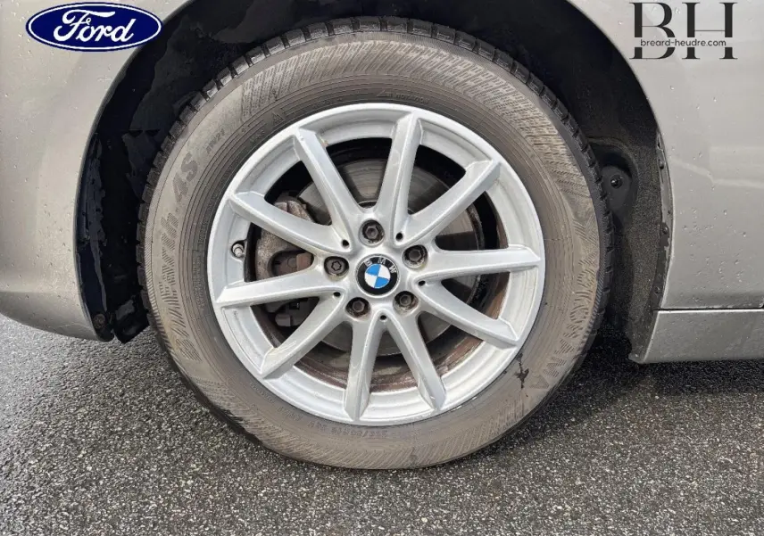 Gros plan sur la roue avant droite d'une BMW Série 2 Active Tourer platinumsilber avec jante alu à 10 branches.